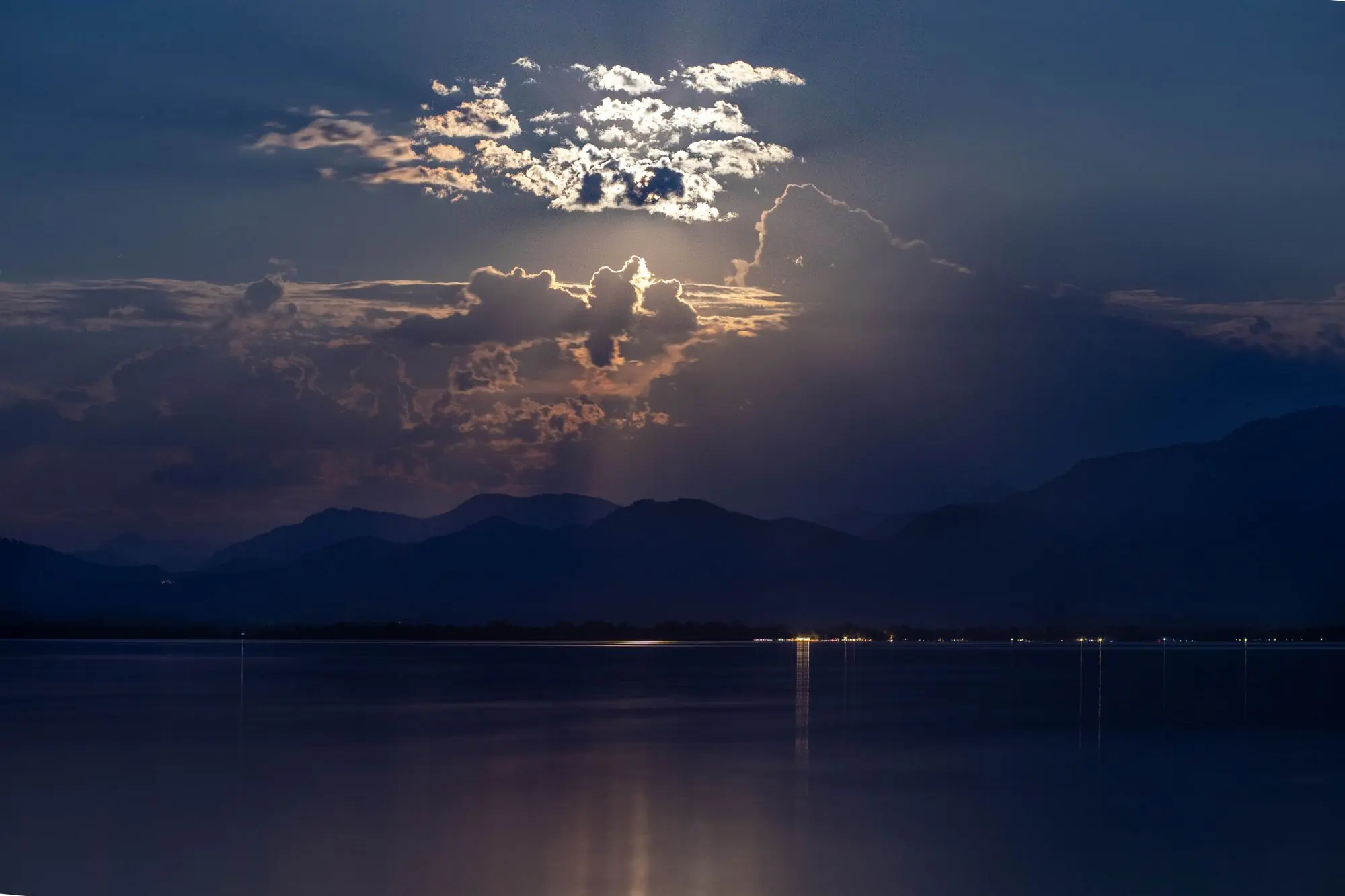 Mondlicht über einem stillen Bergsee bei Nacht
