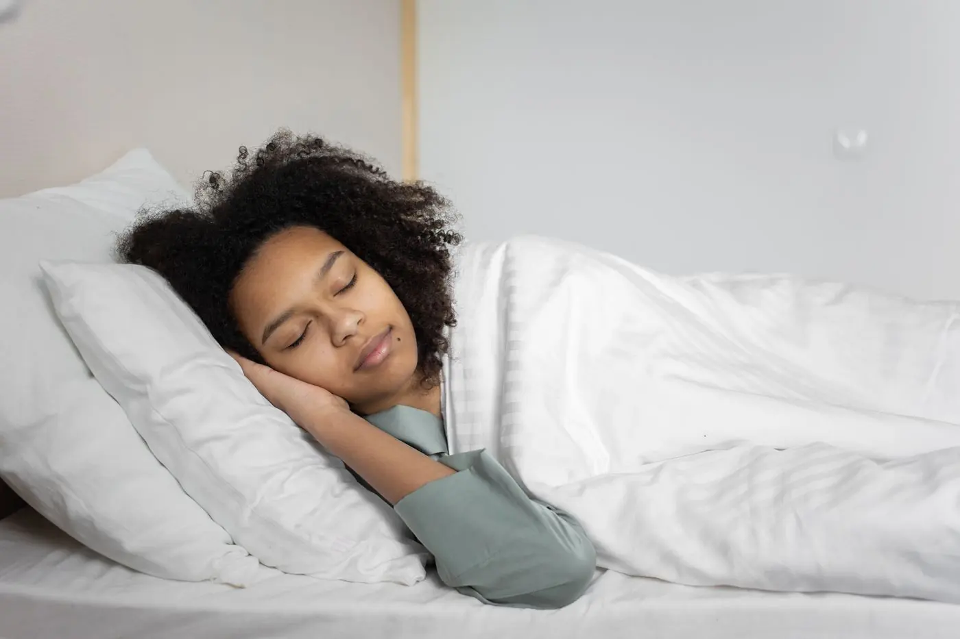 Eine Frau schläft ruhig in einem hellen Schlafzimmer
